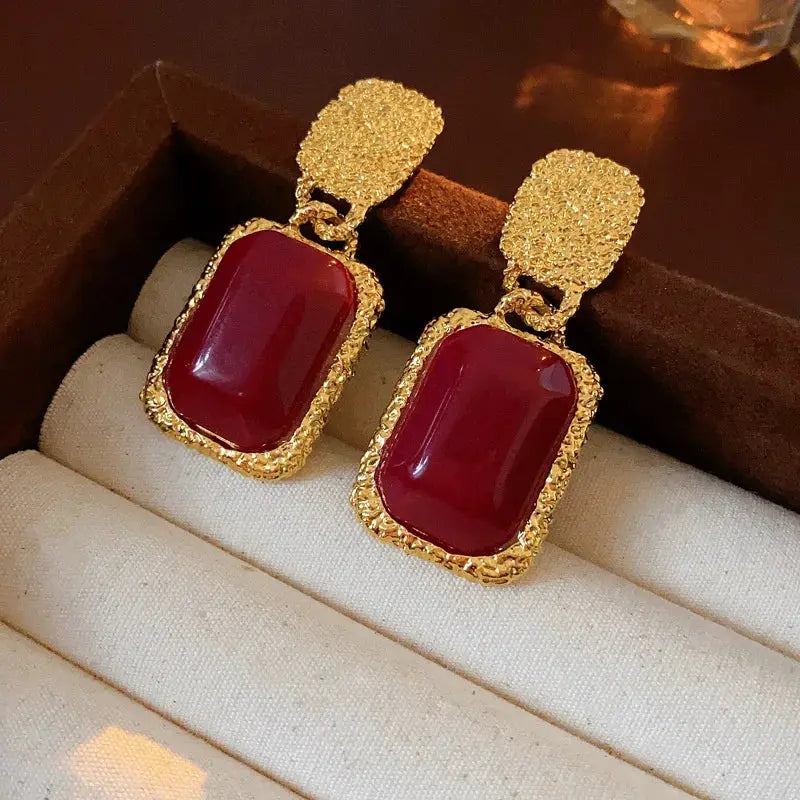 Pair of vintage red resin earrings with large gold-tone geometric oval cabochons