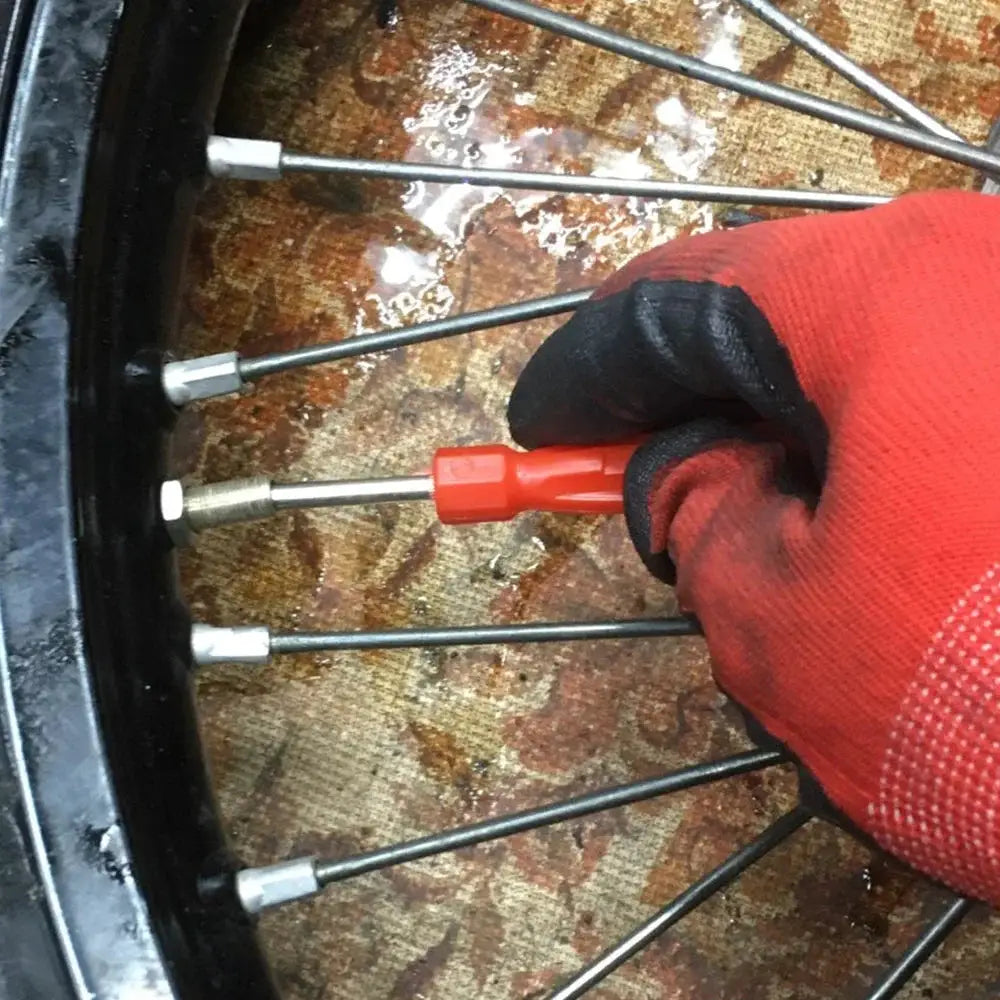 Simples Market copper tire valve core removal tool with red handle, used on a car wheel valve