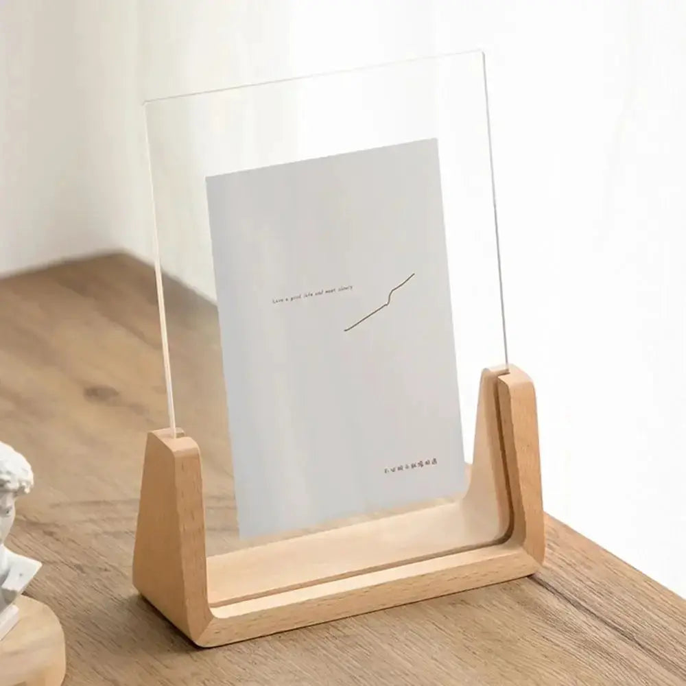 Acrylic U-shaped photo frame with walnut and beech wood base on a desktop by Simples Market