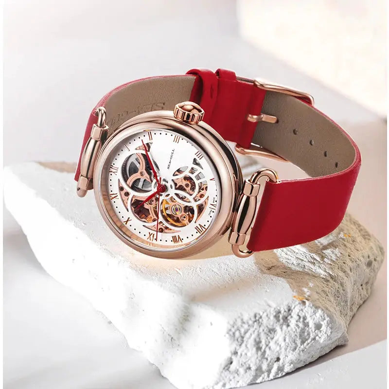 Simples Market Seagull Fashion women's skeleton automatic watch with red leather strap and rose-gold case.