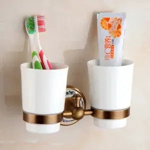 Wall-mounted bathroom accessory set in antique brushed solid brass with two white porcelain cups by Simples Market.