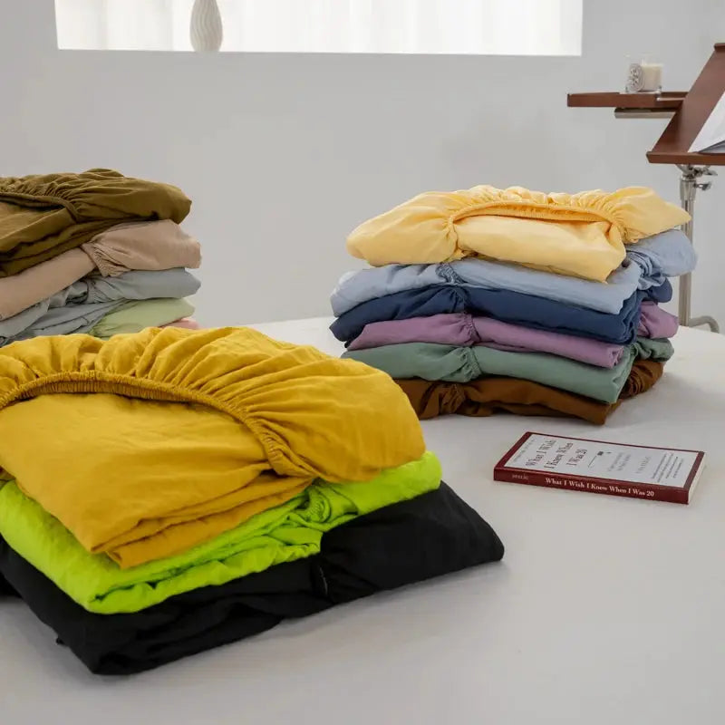 Soft cotton fitted sheets with elastic band, assorted colors stacked in piles