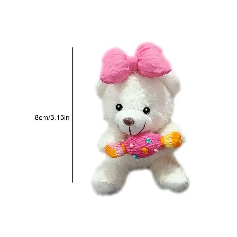 Pilot Bear plush car ornament by Simples Market; white bear with pink bow holding a colorful toy bone, 8 cm tall