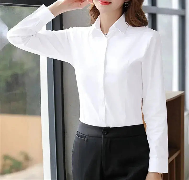 White women's long-sleeve button-down blouse paired with black dress pants