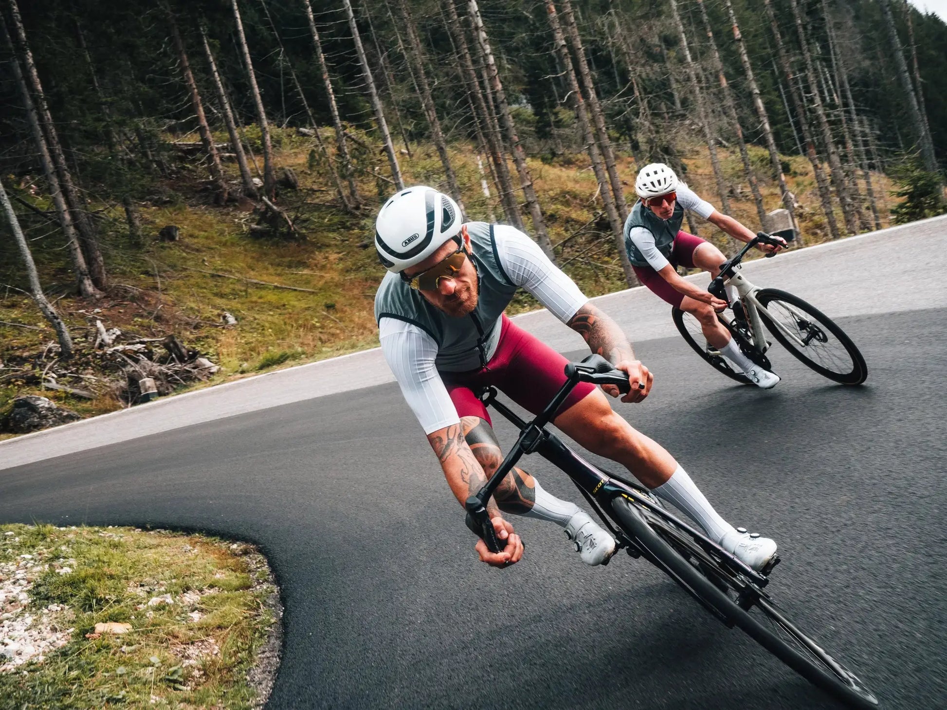 DAREVIE cycling vest worn by two riders on a forest road; gray windproof vests.