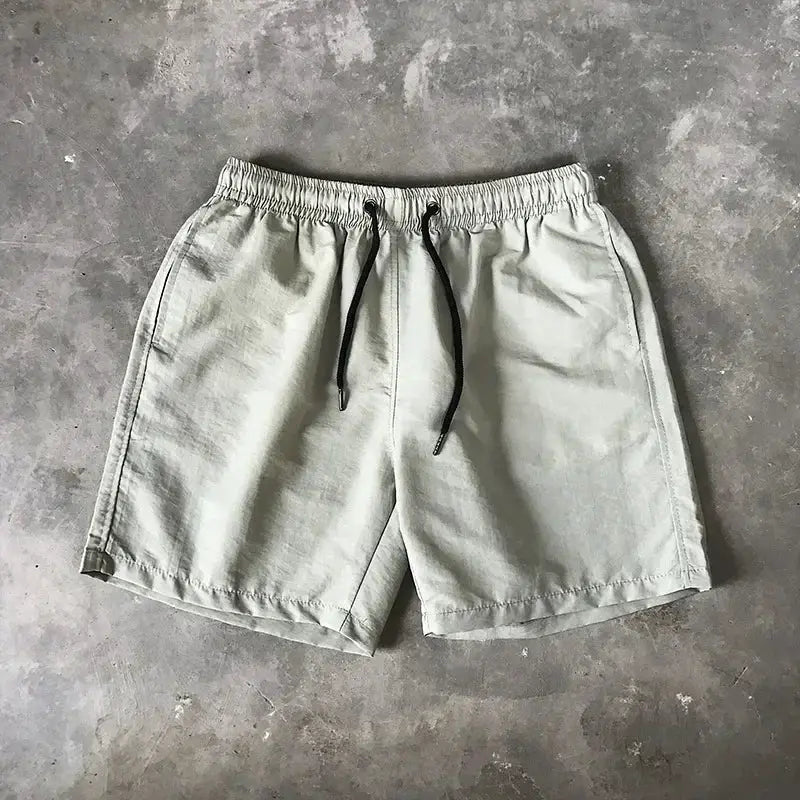 Men's light gray swim shorts with elastic waistband and black drawstring