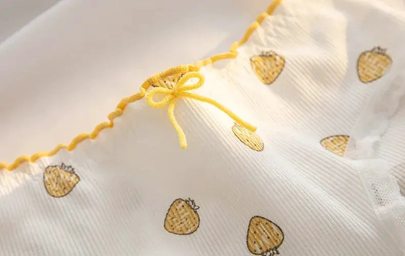 Women's cotton underwear with yellow bow trim on white fabric and pineapple-like print