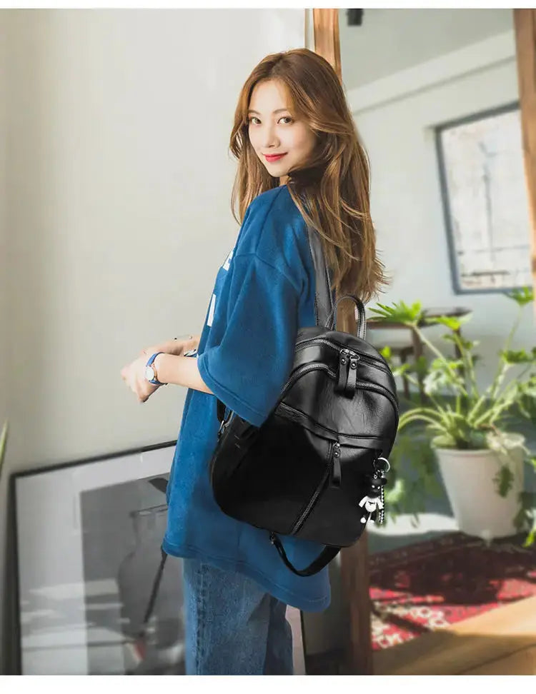 Backpack, black faux-leather casual bag with zip compartments and a bear charm
