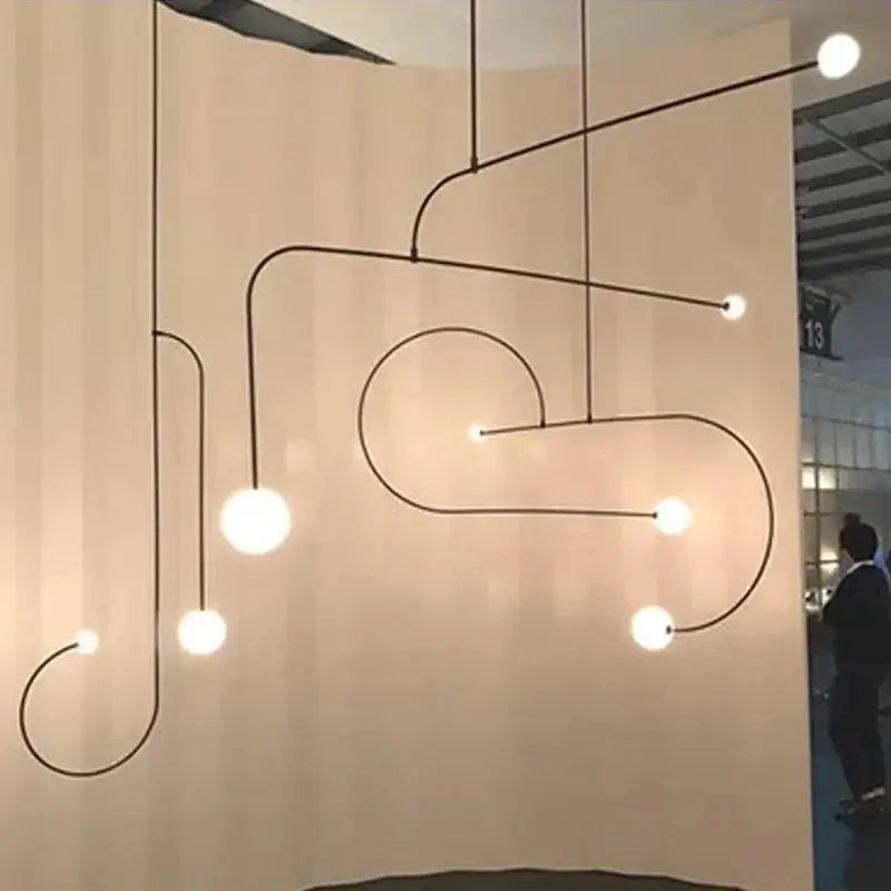 Nordic minimalist chandelier with a geometric black metal line frame and glowing bulbs for living room ambiance.