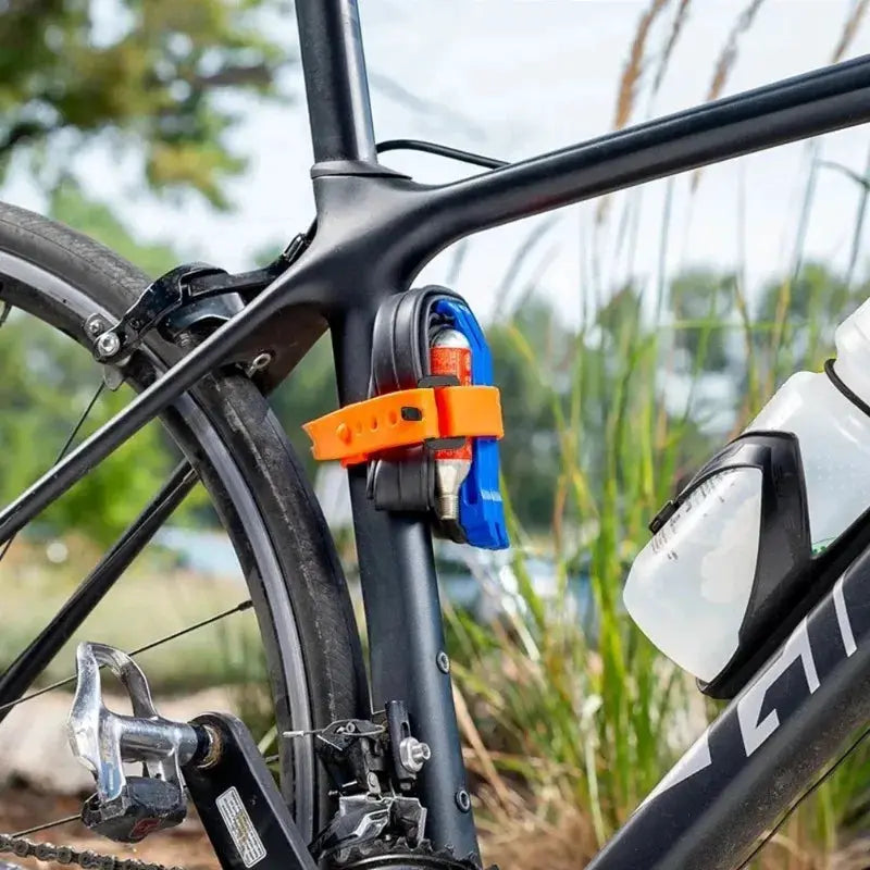 Rubber tension strap cargo belt, orange with blue buckle, strapped to a bicycle frame for cargo lashing