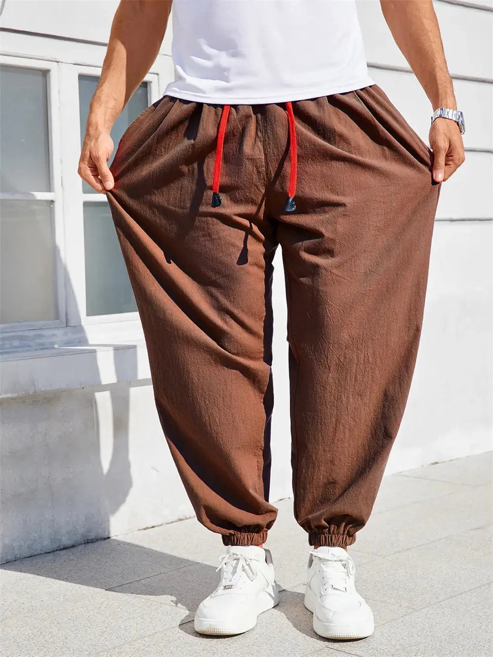 Men's brown cotton-linen harem pants with red drawstring, loose fit with elastic cuffs.