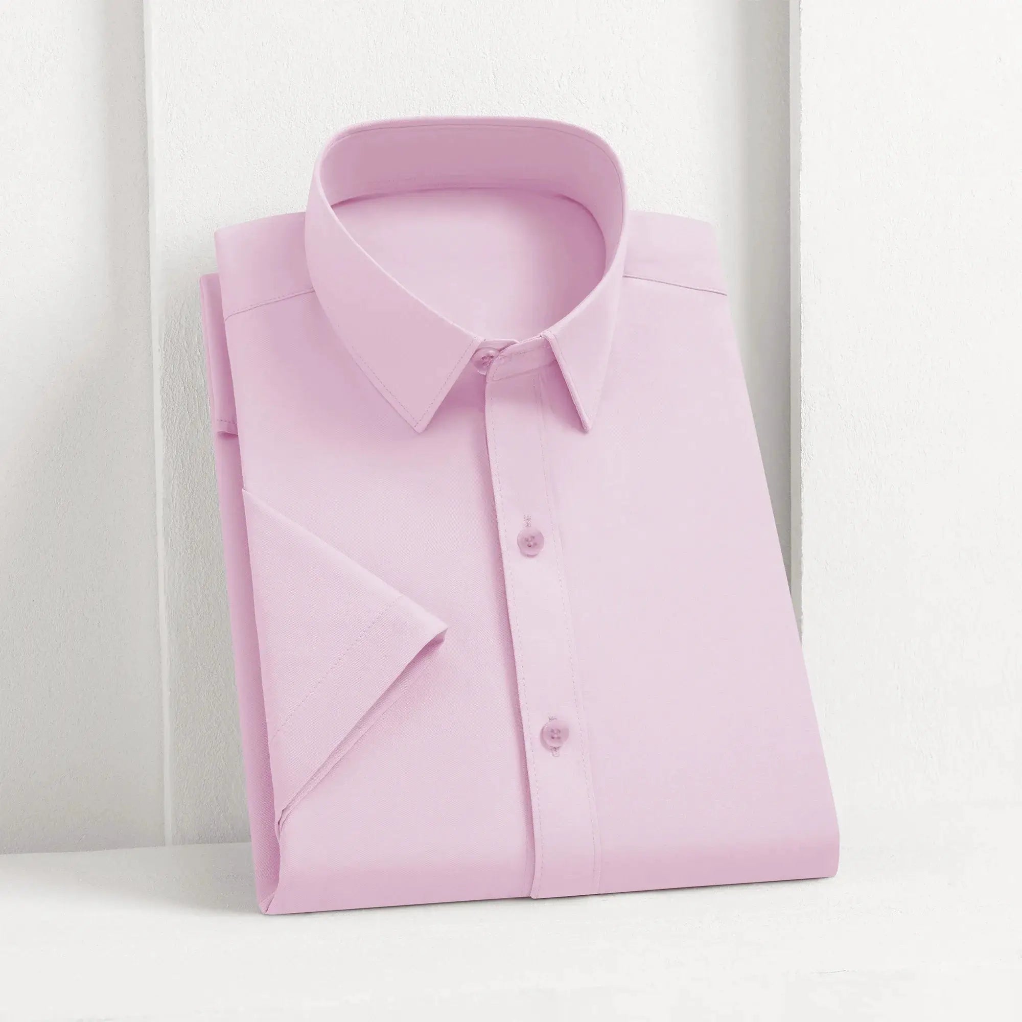 Men's pink solid dress shirt folded with button-down collar, business casual style