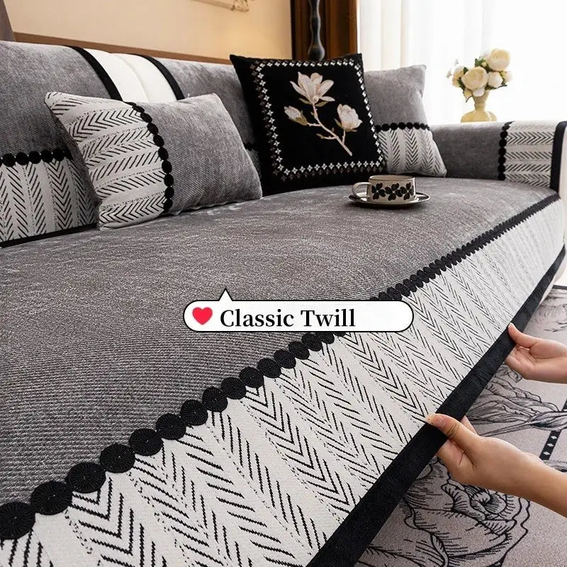 Sofa slipcover with contrast hem in gray twill chenille and black pom-pom border, non-slip fit.