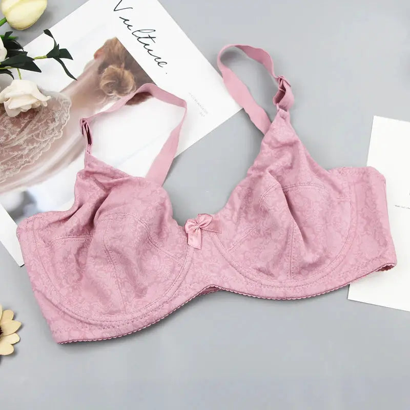 Pink lace bra with bow detail and delicate floral pattern.