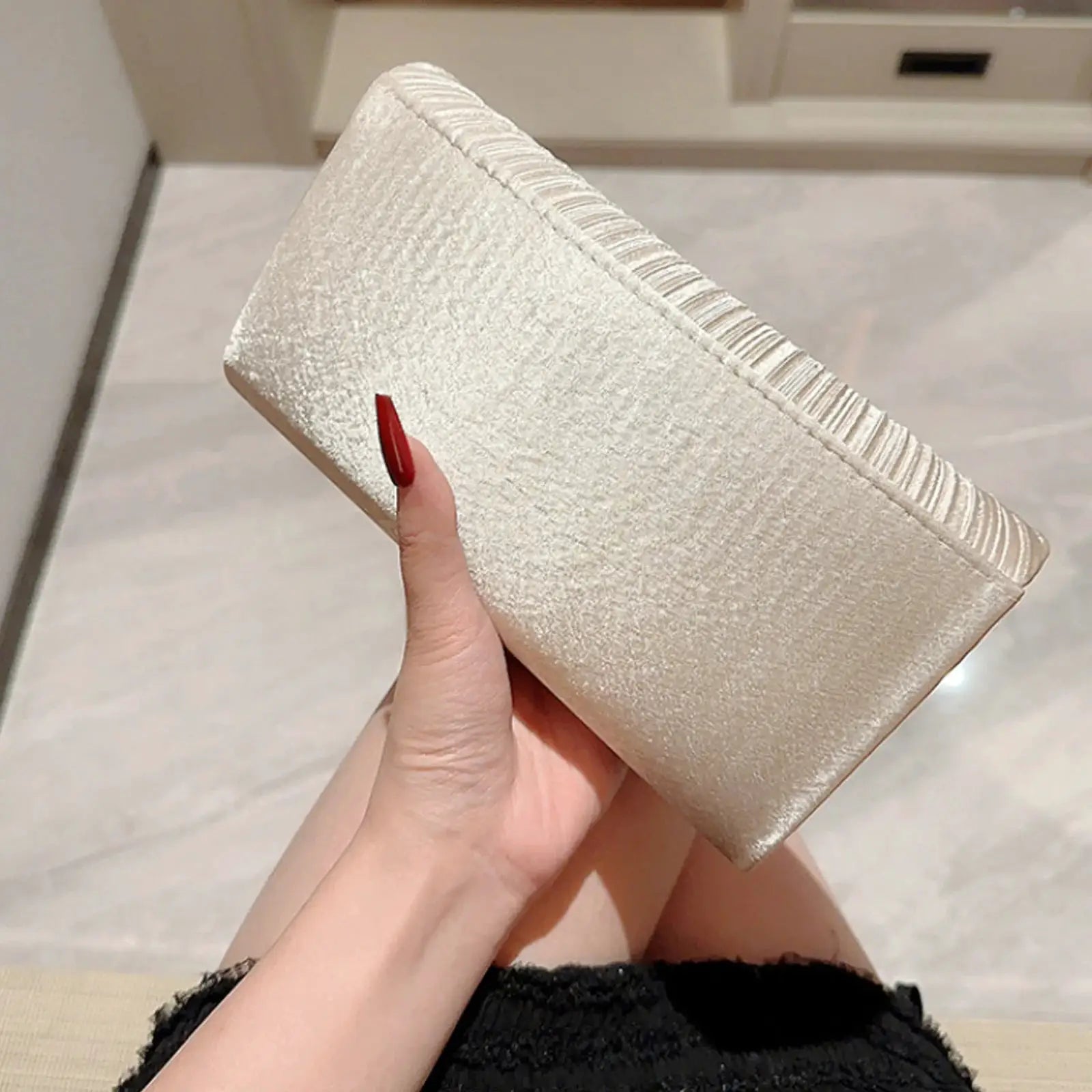 Evening clutch bag in champagne-silver metallic finish with textured surface and decorative edge trim