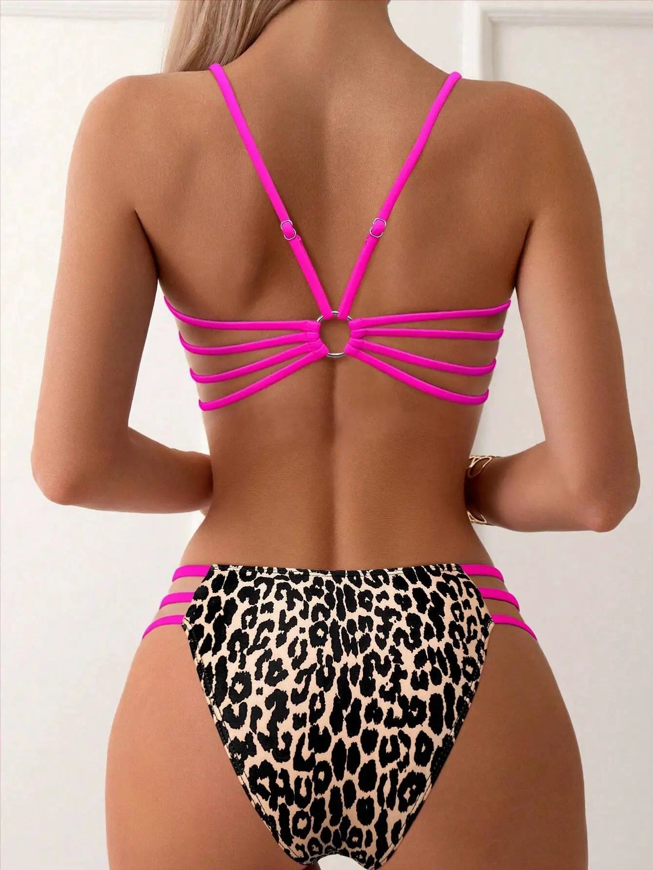 Leopard print bikini set featuring neon pink strappy back top and pink-strap bottom