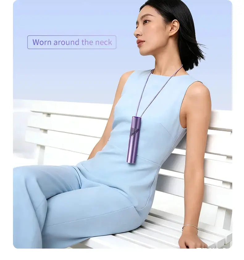 Lipstick-style neck-hung mini fan in purple, worn by a woman in a light-blue outfit