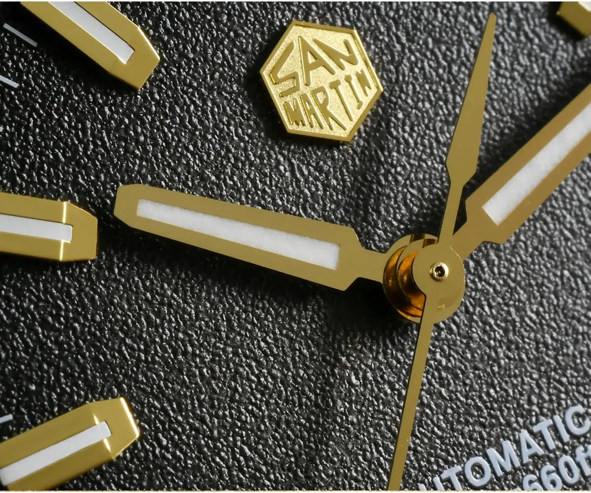San Martin gold-tone dive watch hands and markers with SAN MARTIN logo badge on textured surface