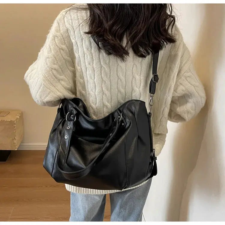 Soft interior compartment shoulder bag in black PU leather with zip pockets and crossbody strap