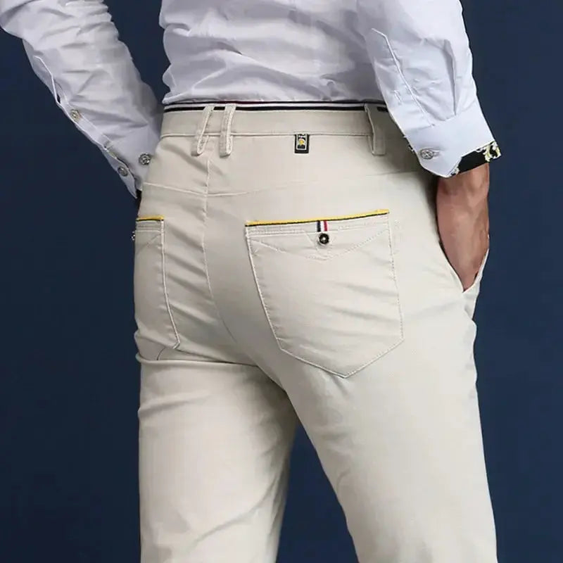 Men's Simples Market cotton chinos in light beige with yellow-trim back pockets.