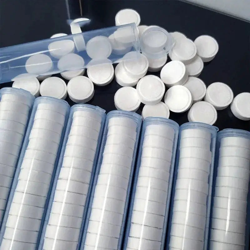 Compressed travel towels tablets in clear plastic tubes; white nonwoven disposable towels