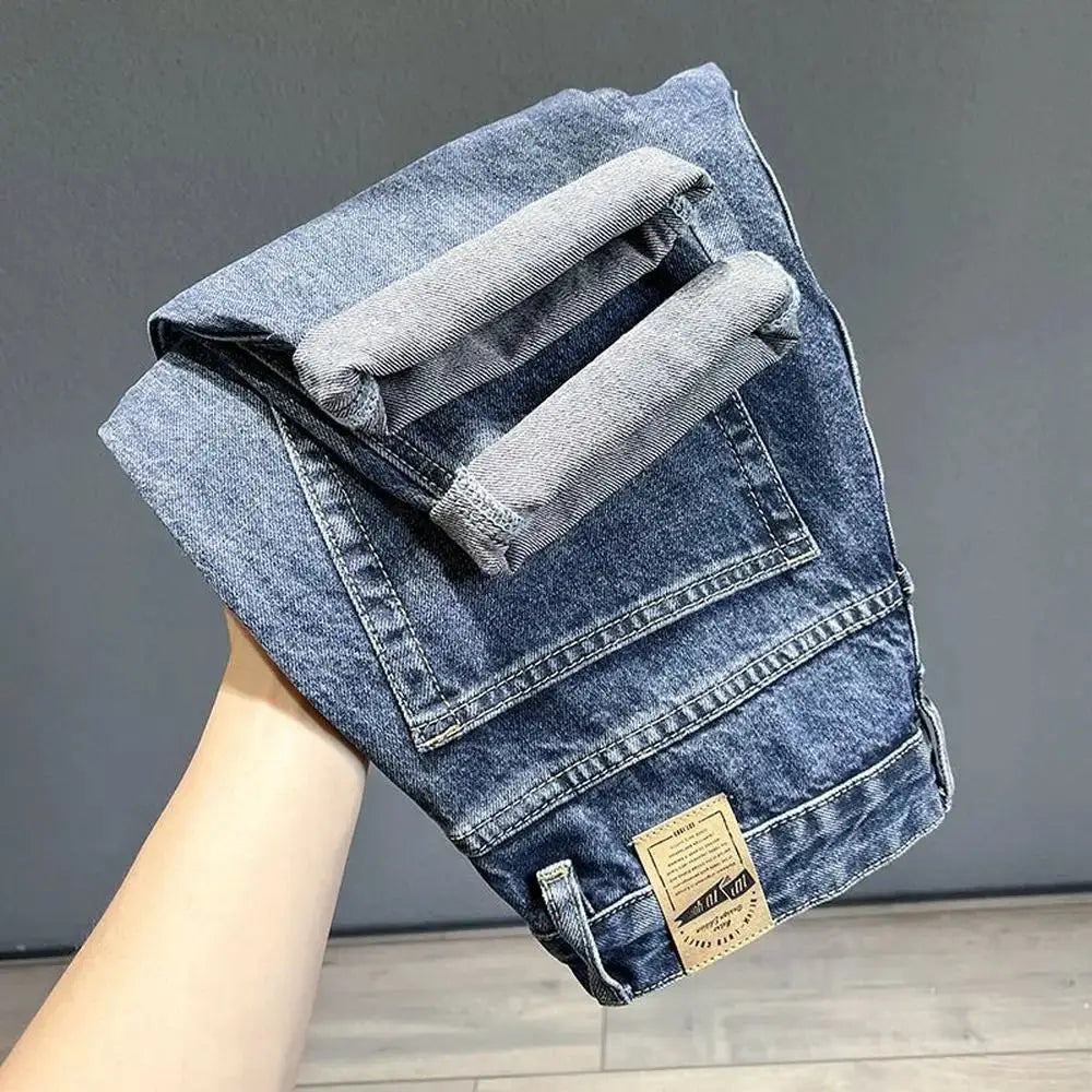 Men's blue denim jeans with loose tapered fit and rolled cuffs.