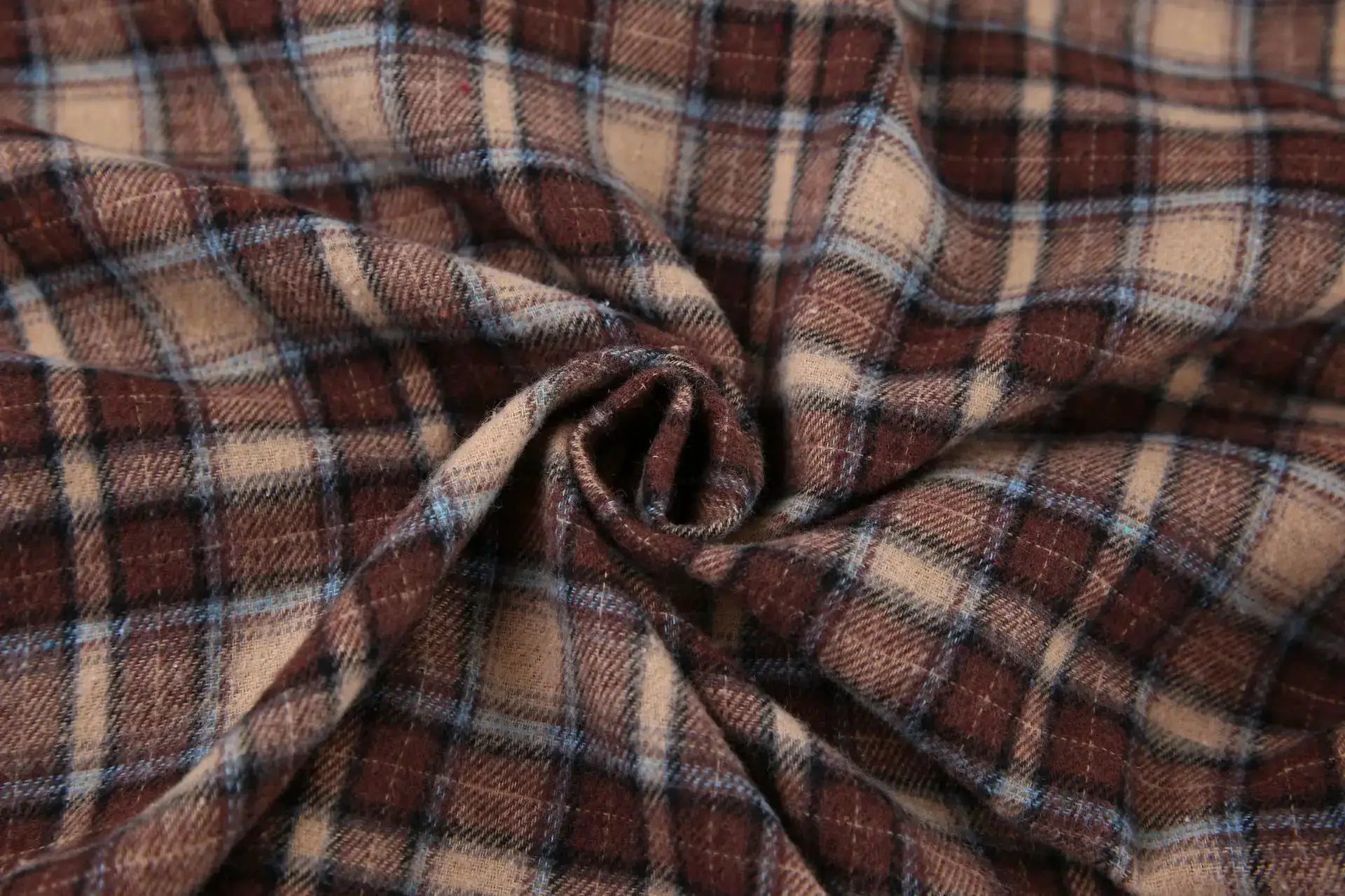 Plaid shirt fabric in brown and tan with blue checks; close-up texture.
