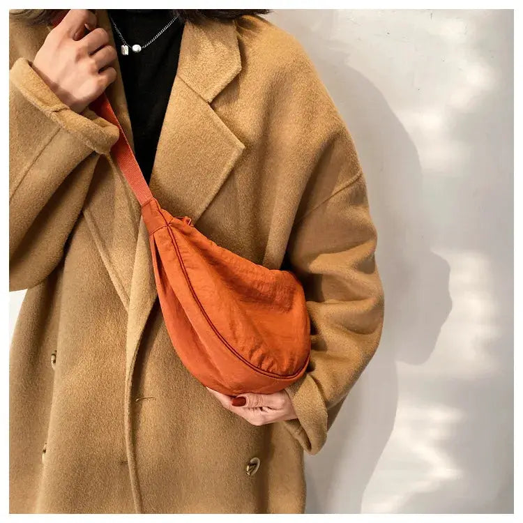 Crossbody bag, orange padded nylon, compact curved design.