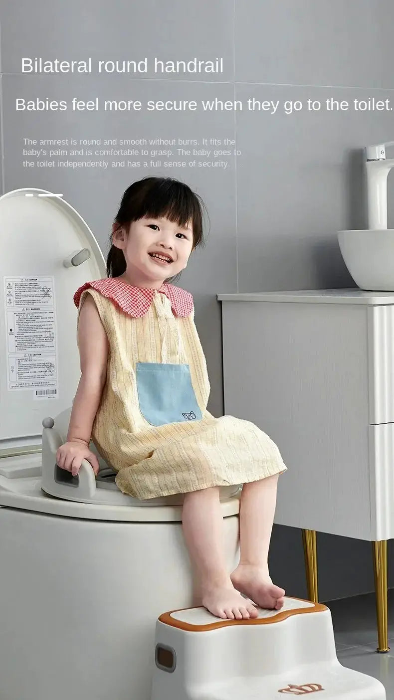 Baby and child toilet seat with step stool; white seat with orange-trim stepping stool, child seated.