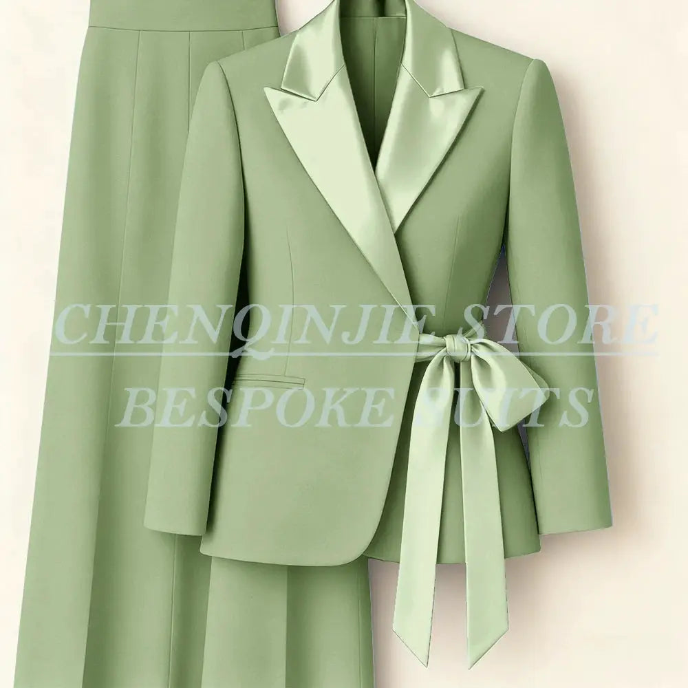 Women's sage green two-piece blazer suit with satin peak lapels and waist belt, matching pants