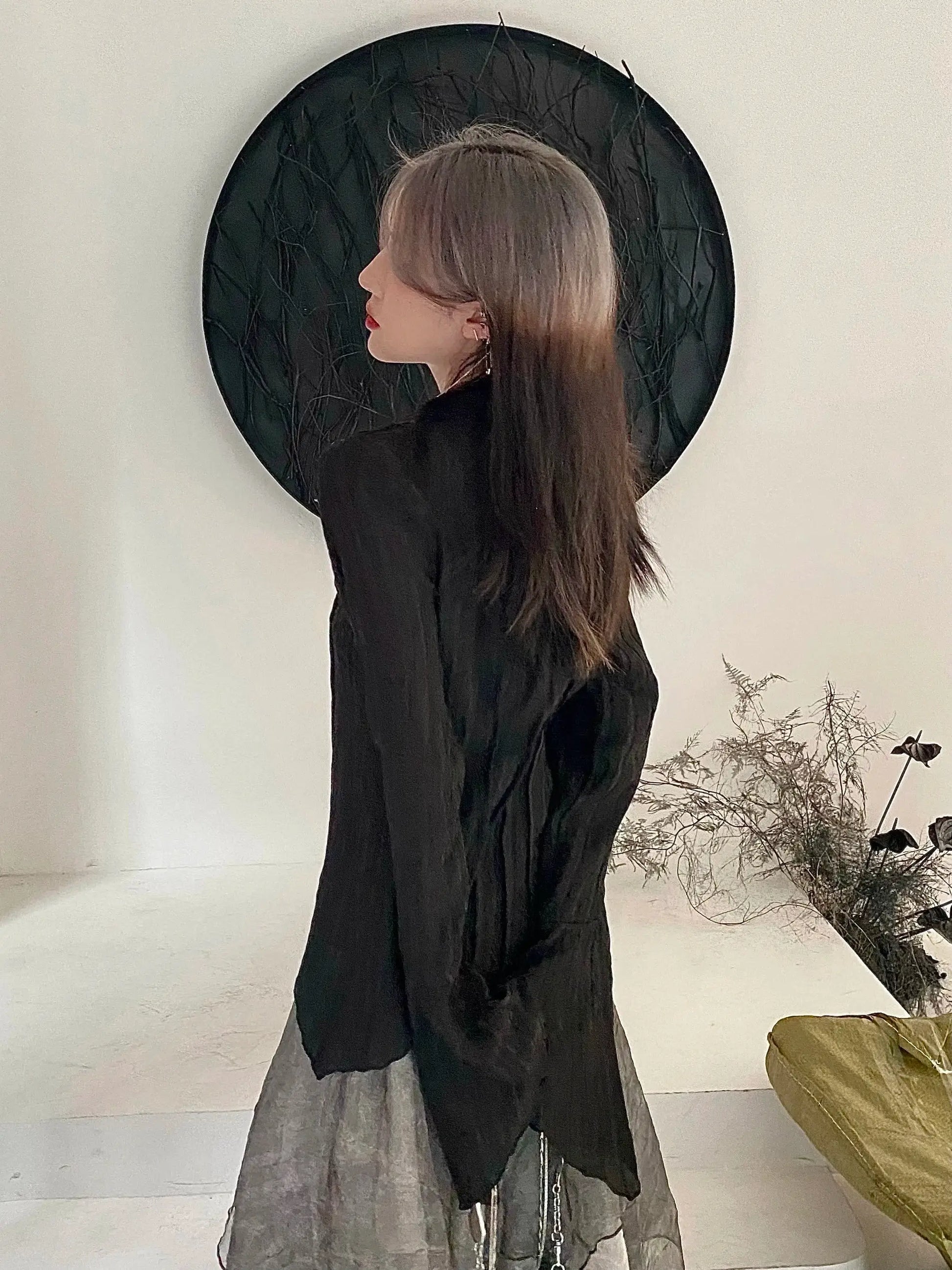 Karrram Gothic black blouse worn by a woman in side profile, with a layered grey sheer skirt.