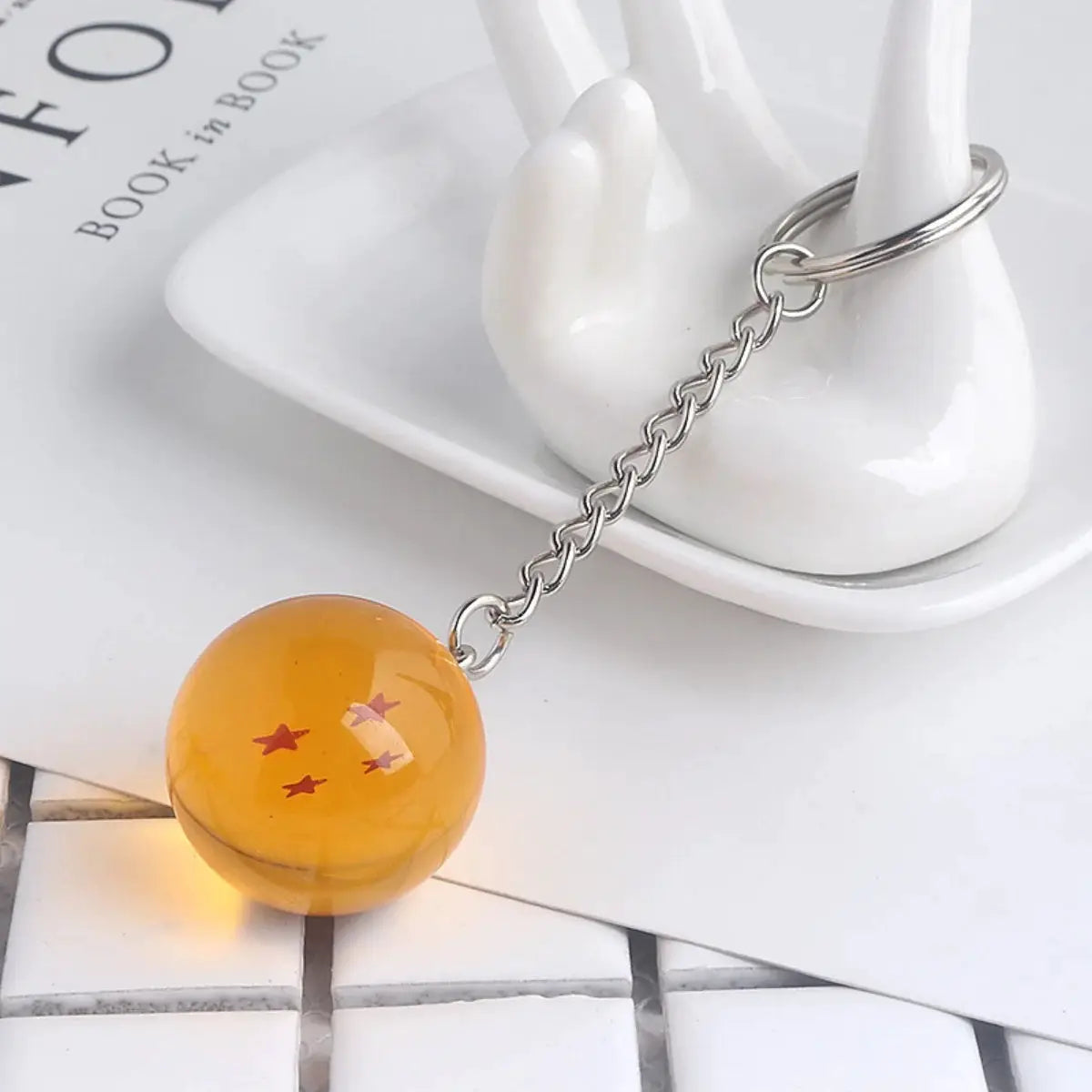 Dragon Ball keychain bead pendant, orange translucent sphere with red stars on a metal chain and ring