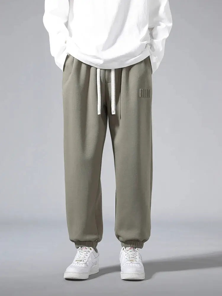 Men's olive jogger sweatpants by Simples Market; cotton/polyester, drawstring waist, baggy hip-hop fit, sizes 6XL–8XL.