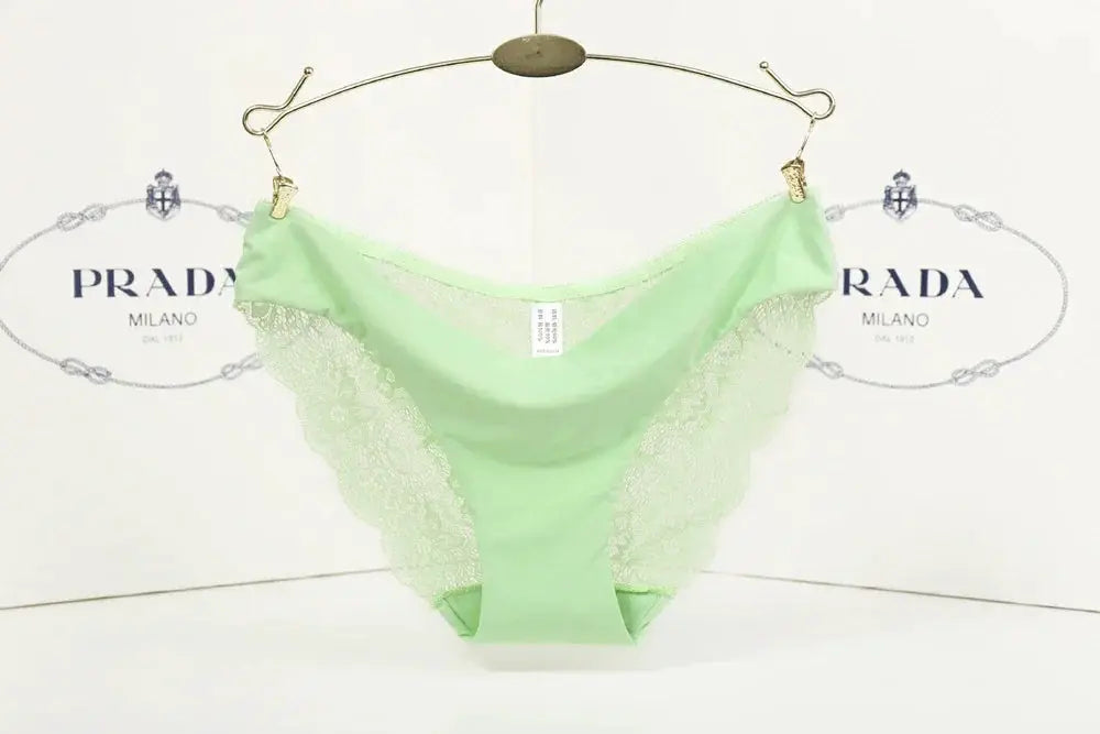 Mint green lace low-rise thong; breathable cotton blend, Simples Market, on a hanger with Prada backdrop.