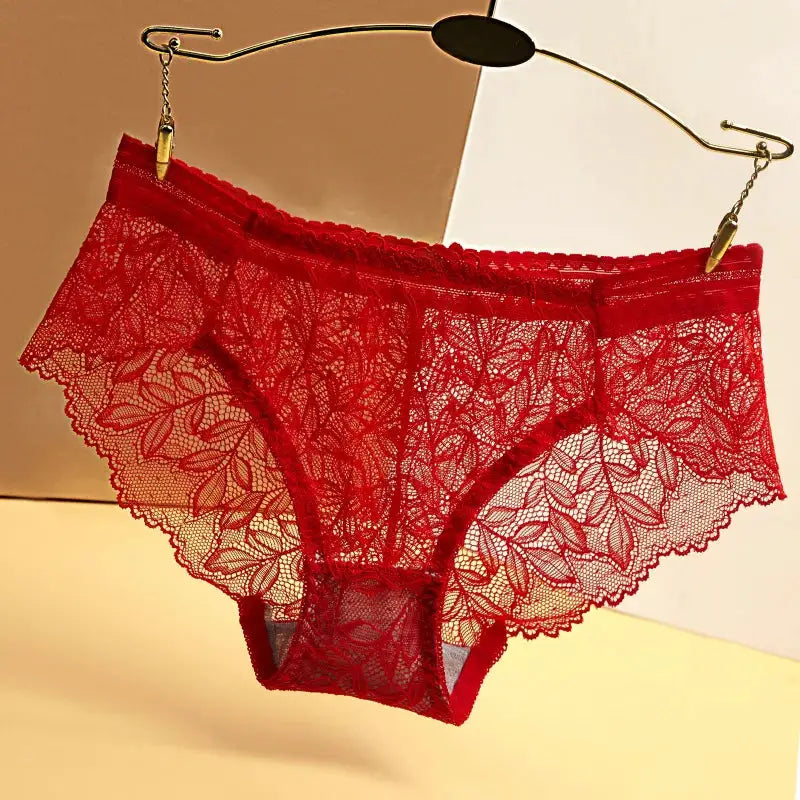 Women's red lace panties, low-rise briefs with floral lace, hanging on a hanger