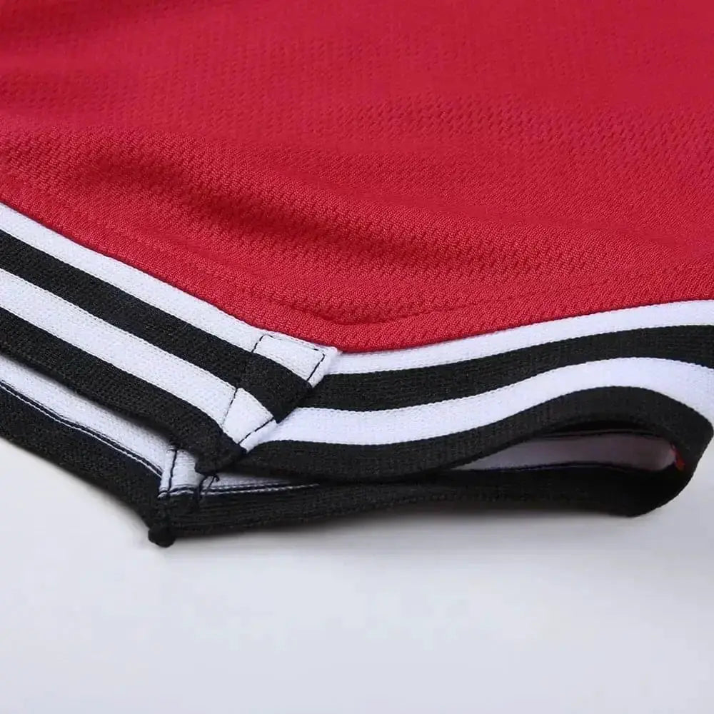 Men's basketball shorts in red mesh with black and white striped waistband; Simples Market sportswear.