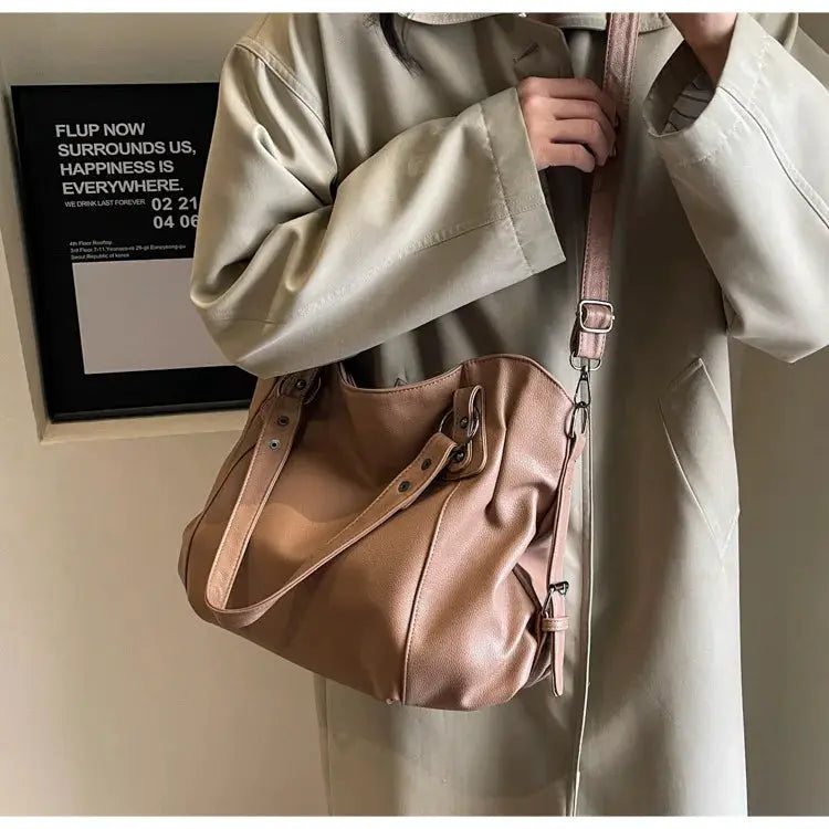 Soft interior compartment shoulder bag in tan PU leather with zipper closure, dual handles and detachable strap.