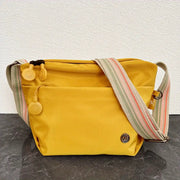Simples Market yellow nylon crossbody bag with adjustable wide striped strap and zipper closure