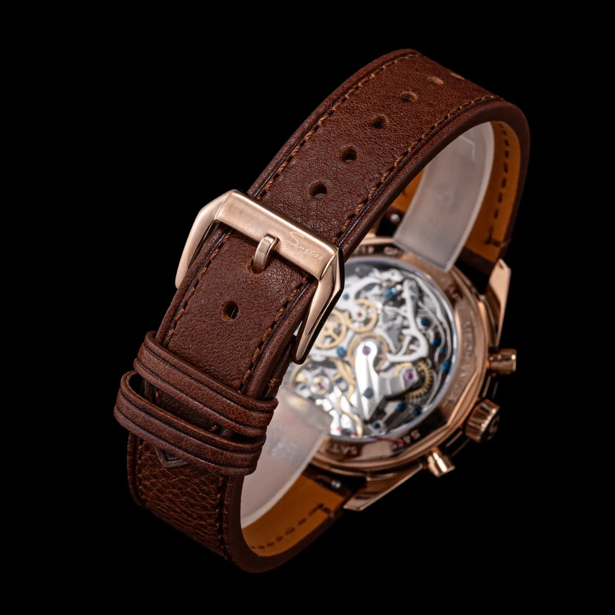 Sugess men's watch with brown perforated leather strap and rose-gold case; sapphire back reveals skeleton movement.
