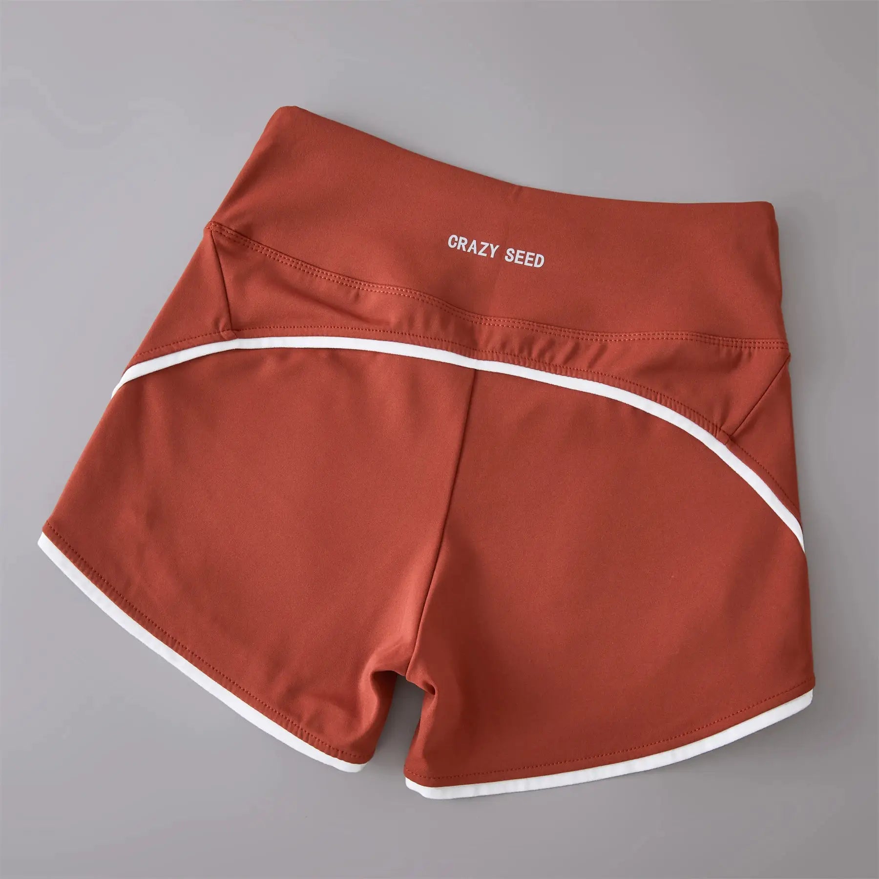 Peach high-waist sports shorts with white piping and Crazy Seed branding.