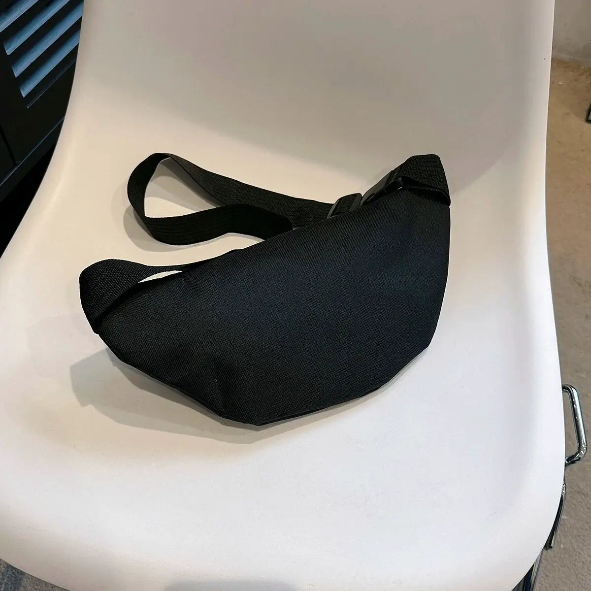 Black fabric fanny pack waist bag with adjustable strap for hands-free crossbody use