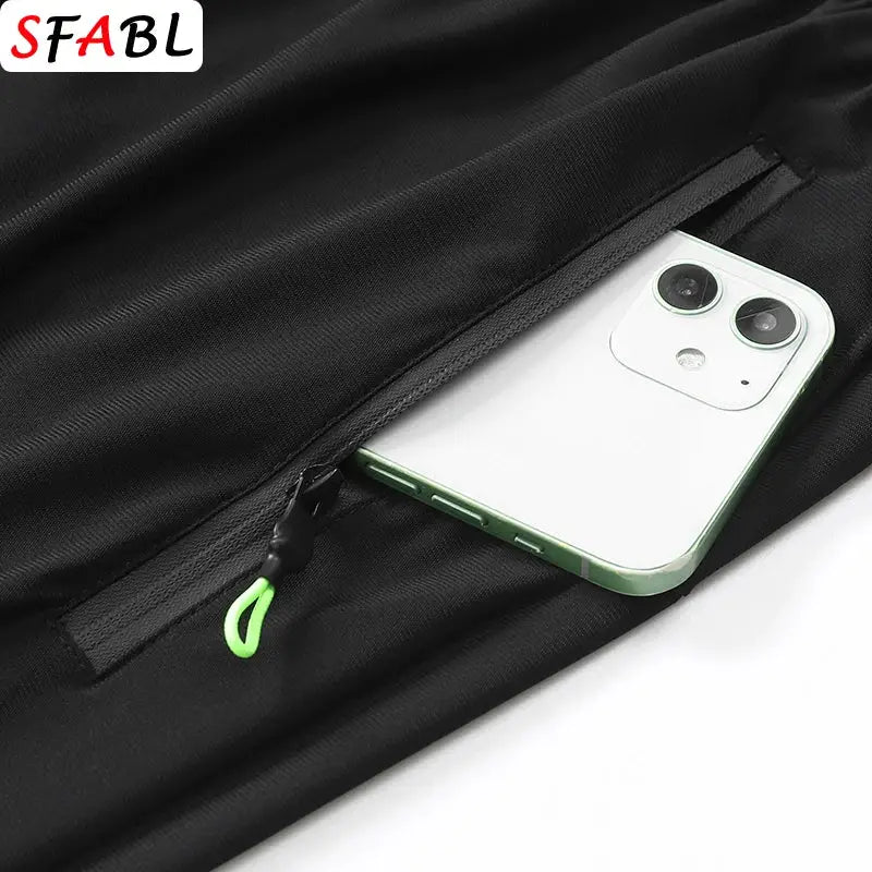 Men's black sports shorts with zip pocket holding a phone and neon green zipper pull, SFABL logo
