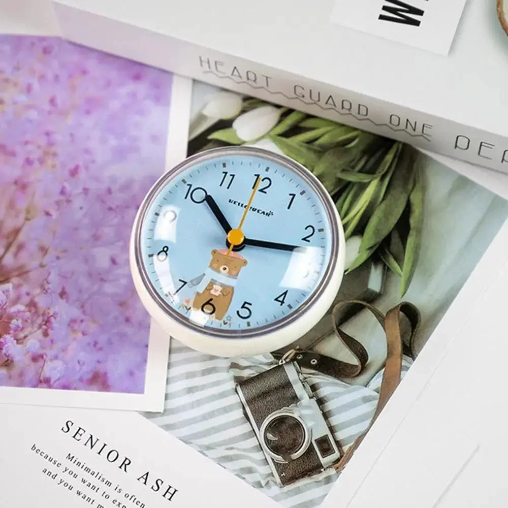 Mini Sucker wall clock with light blue face featuring a bear illustration, white bezel, 7 cm quartz timepiece
