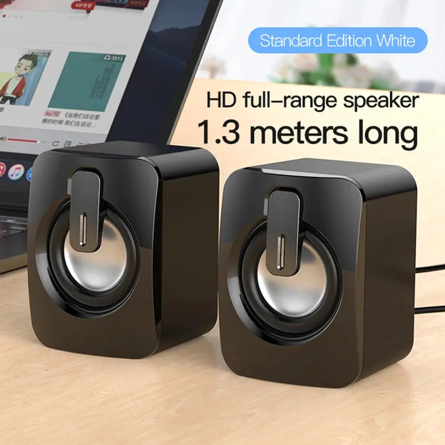Simples Market computer speaker set: two black USB-powered desktop speakers with round metallic drivers.