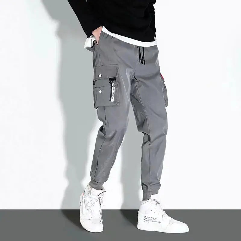 Simples Market 2025 men's tactical cargo pants in grey with multi-pocket design and jogger cuffs.