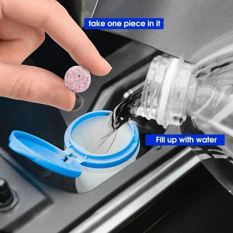 Car windshield cleaner effervescent tablet from Simples Market, pink speckled, dissolving in a blue-capped water bottle.