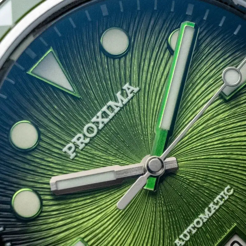 Proxima dive watch dial close-up with green sunburst face, luminous markers, and silver hands