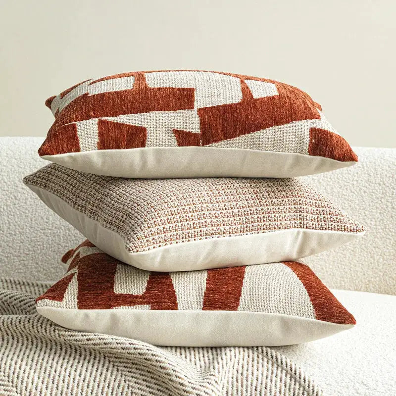 Decorative pillows: three ivory and rust-red with a woven geometric pattern