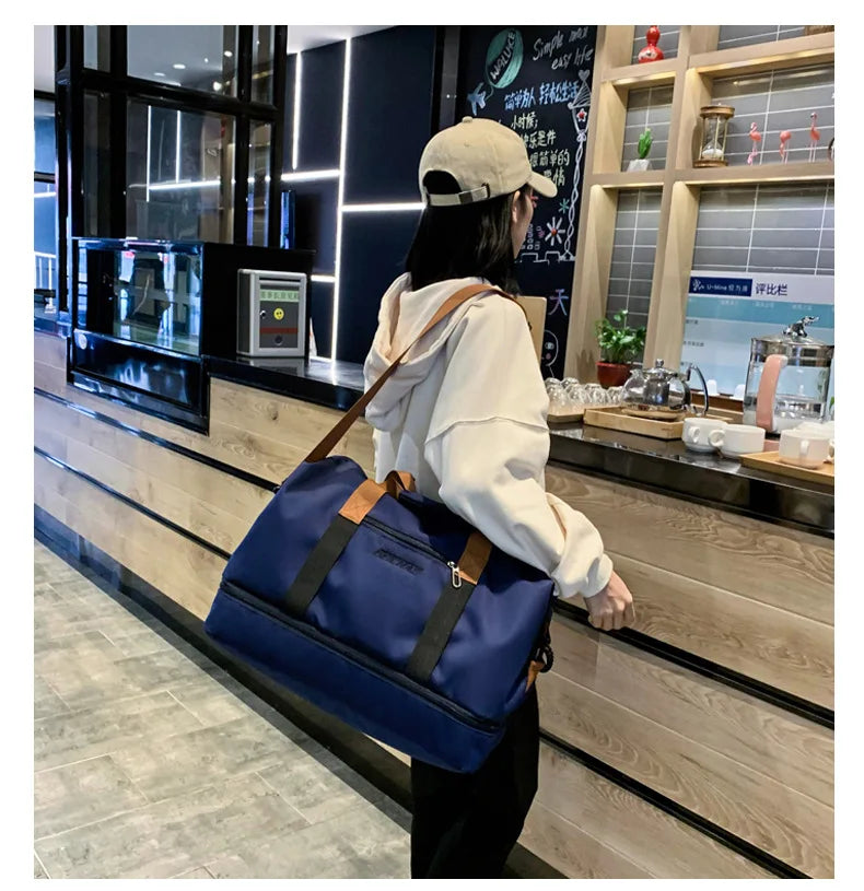 Large-capacity blue travel gym bag with brown handles and black shoulder strap