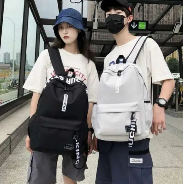 Two fashion trend backpacks for men and women, black and white, large-capacity casual bags worn by two models.